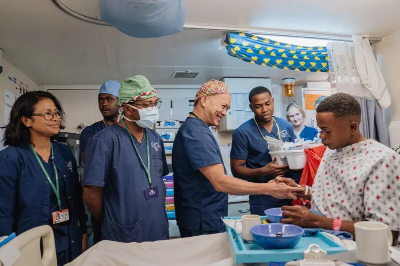 Dr. David Chong, Maxillofacial Head and Neck Surgeon, with Romain Raherison, ETA Surgeon, during morning rounds with Joseph, cleft lip patient.