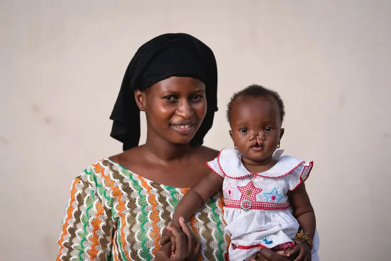 Mariama, a sponsored child maxillofacial patient, with her mother before surgery in Africa