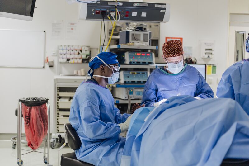Dr. Tjeerd de Jong, Reconstructive Plastic Surgeon, and Sue Khor, Operating Room Nurse, performing surgery on Abubakarr, plastics patient.
