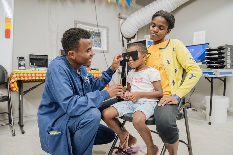 Anjaratina, ophthalmic patient, with Kenny Judicael Tianaina Basilson, Day Crew, getting her eyes checked.